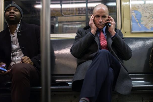 Commuters using their phones on a New York subway this month.